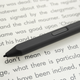 A close-up of the tip and shortcut button of the Kindle Scribe's Premium Pen option, sitting on the Scribe's screen.